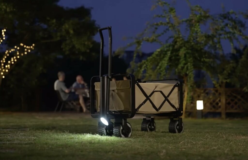 an electric outisan e wagon is outside on a campsite in the evening