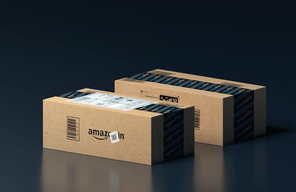 Boxes of Amazon branded parcels sit in a dark studio shot.