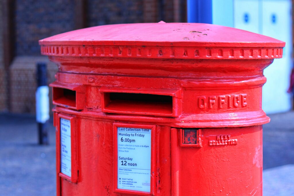 A red post office box, likely in the UK.
