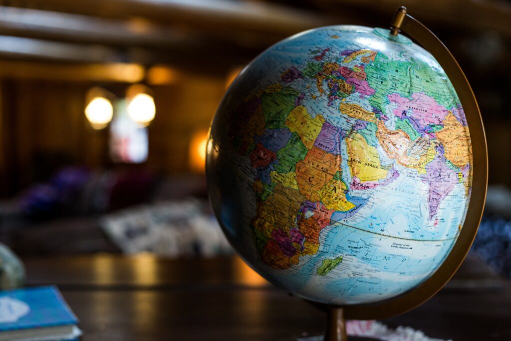 A globe on a stand sits on a desk.