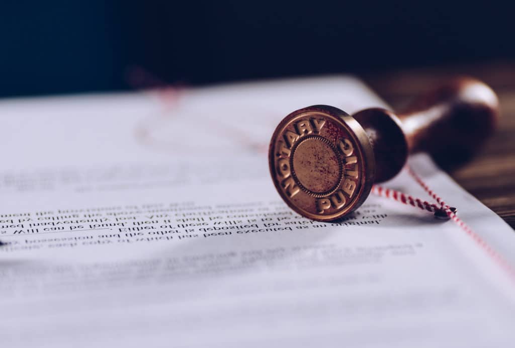 A notary stamp lays across a document.