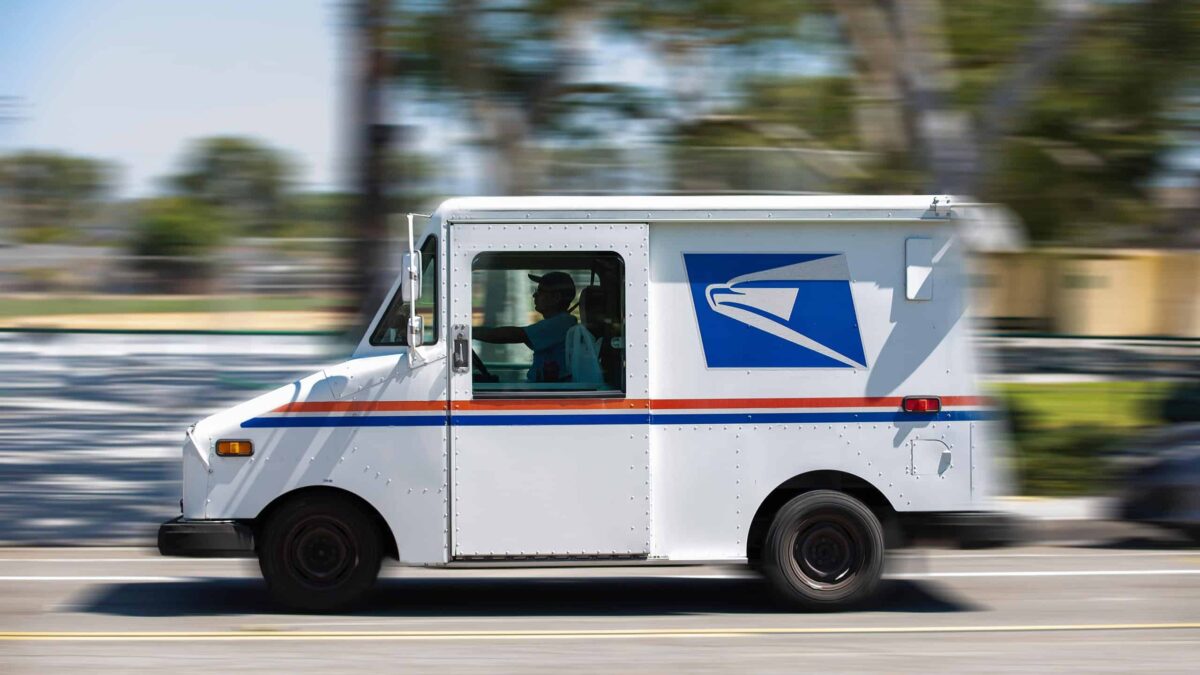 A USPS delivery truck zipping by on the street.