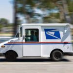 A USPS delivery truck zipping by on the street.