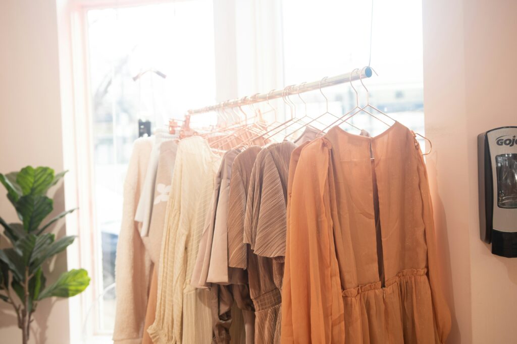 Orange and cream midi dress with pockets hang on a rack in a boutique.