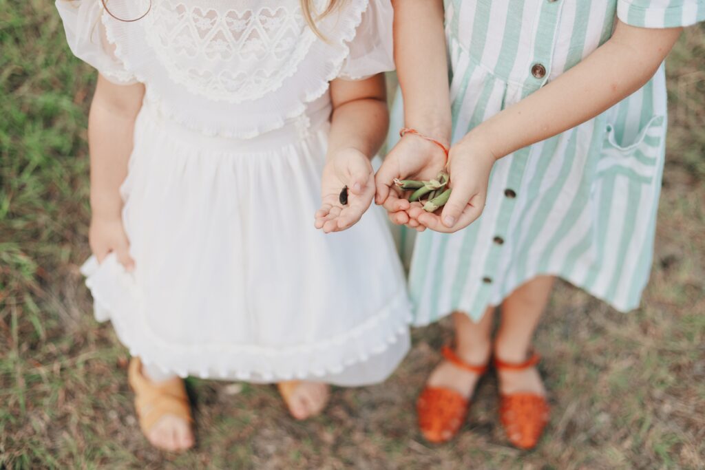 Two young girls wearing summer dresses with pockets.