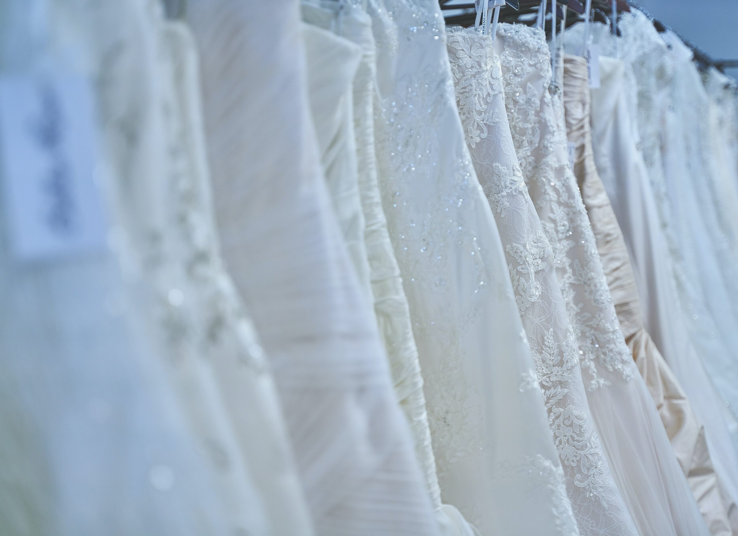 Wedding dresses with pockets are on a rack.