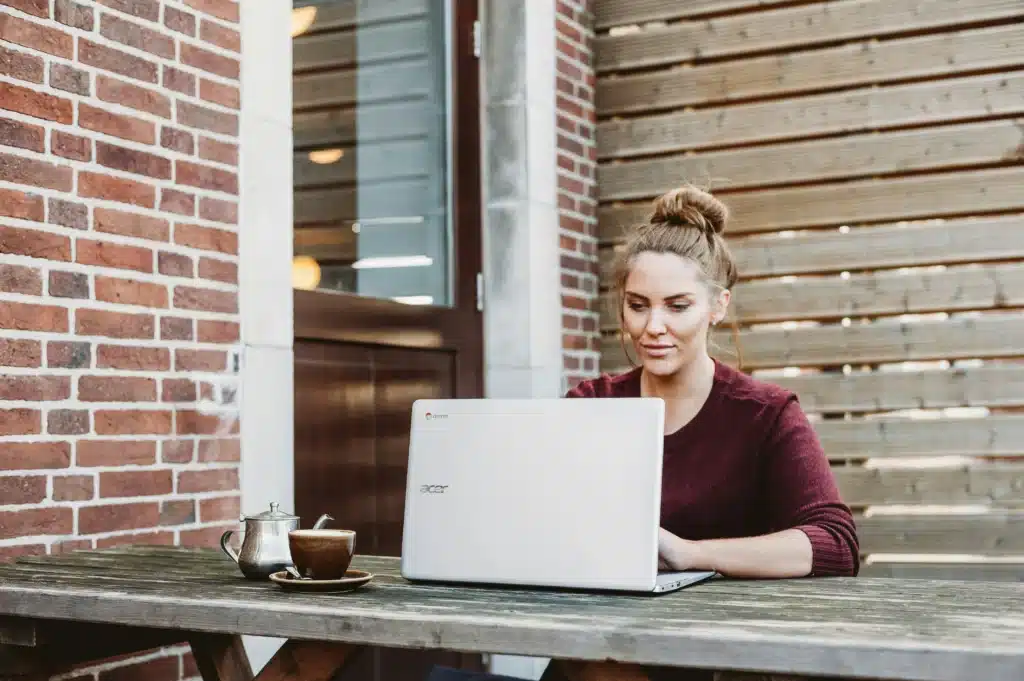 A woman is using a laptop to order more laptops from America with PostFromUS.