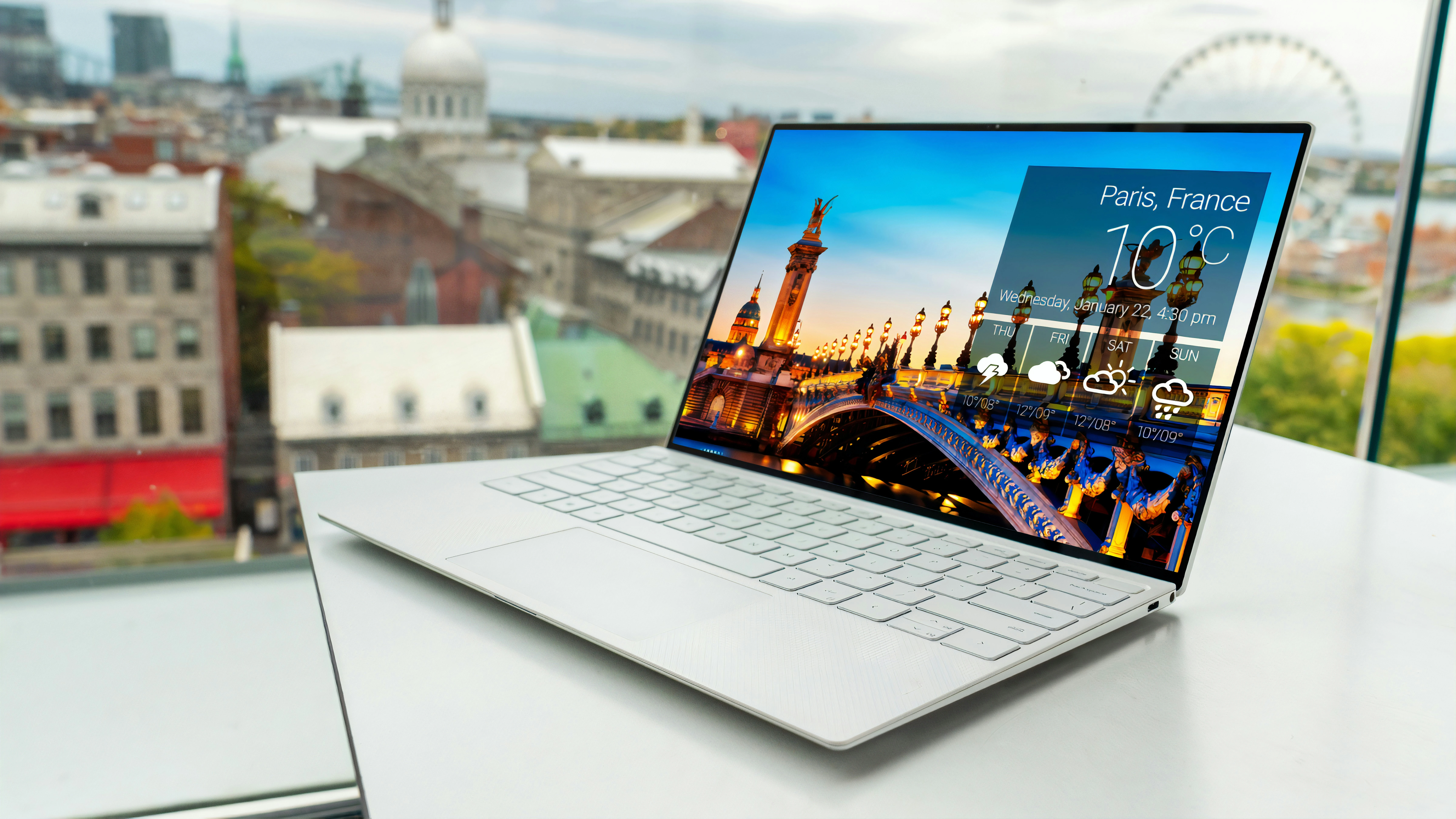 a laptop from America is on a balcony in Paris, with the Eiffel tower in the distance.
