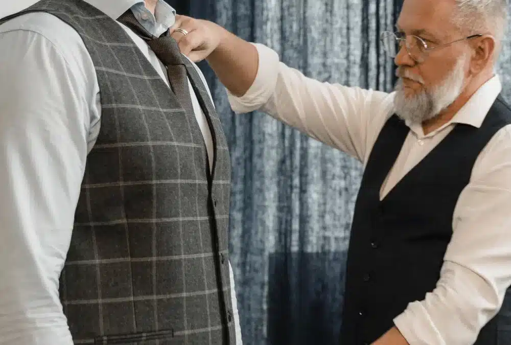 a man wearing a tweed vest suit is being measured by a tailor for american sizes in germany