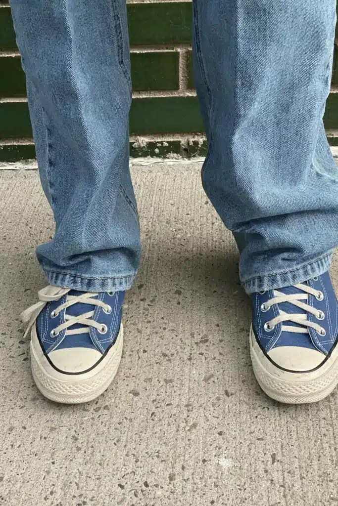 a shot that focuses on the blue shoes of someone wearing jeans. their shoes are american, so they would have to convert sizes in germany to get those shoes.