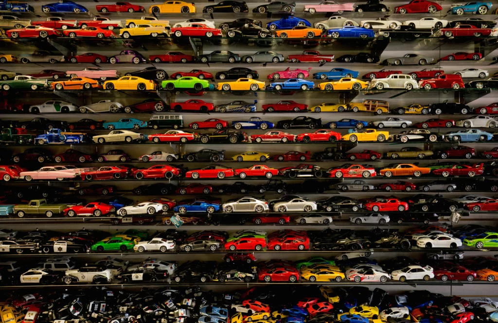 a model car collection on a large shelf with many tiers 