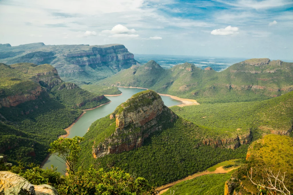 Tall hills with a river or lake running in between. Very green scenery in South Africa.