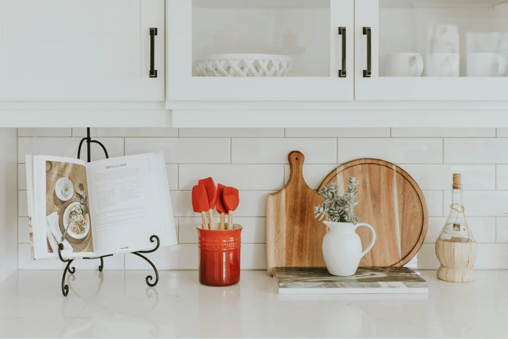 Spring flowers fill a vase on a kitchen counter with kitschy accessories.