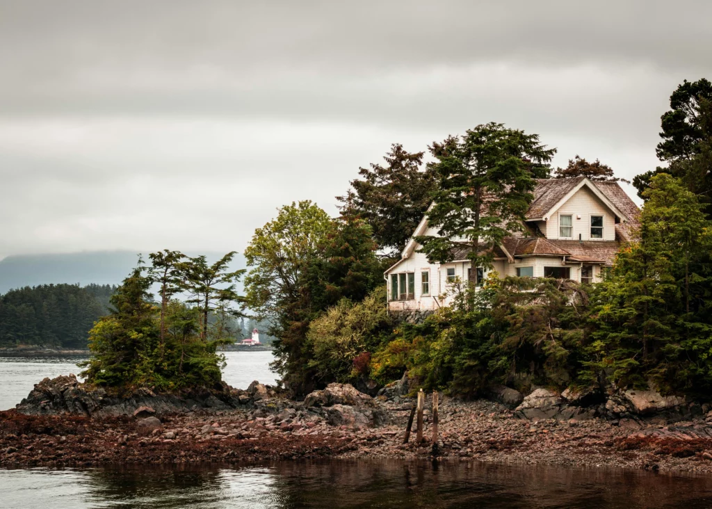 An Alaskan house on the edge of a lake on a grey day.